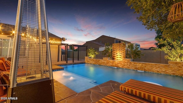 pool at dusk featuring a patio