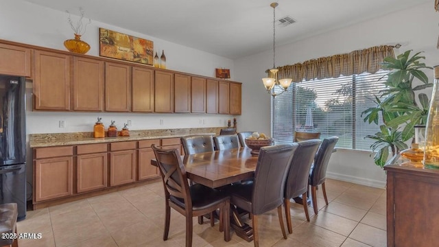 tiled dining area featuring a chandelier