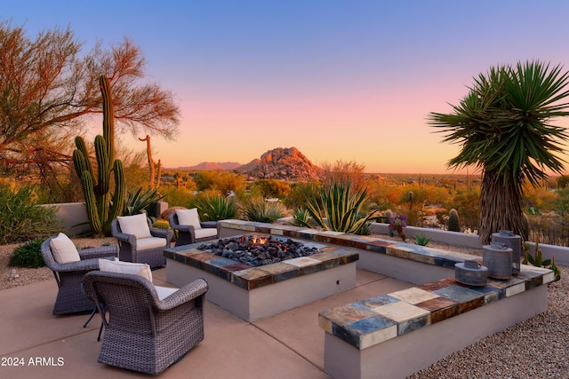 patio terrace at dusk with a mountain view and an outdoor fire pit