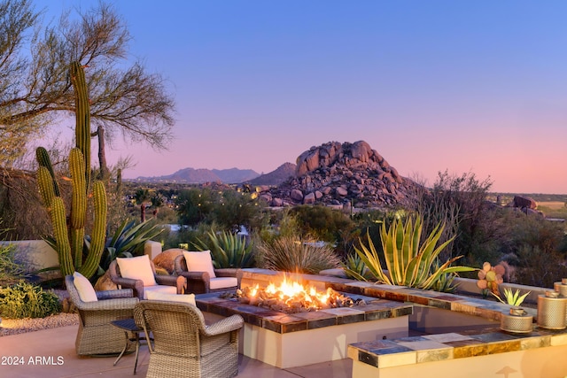 patio terrace at dusk with a mountain view and an outdoor fire pit