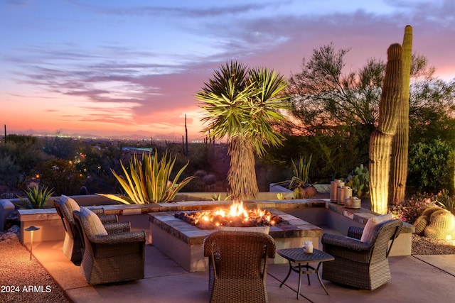 patio terrace at dusk featuring a fire pit