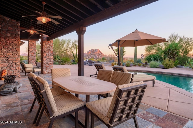 patio terrace at dusk featuring ceiling fan