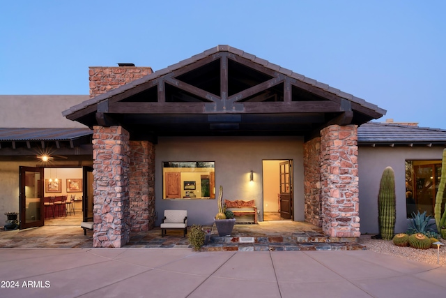 exterior entry at dusk with a patio