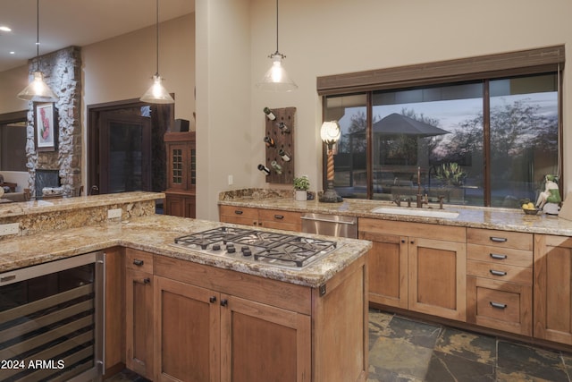 kitchen with wine cooler, sink, stainless steel appliances, and decorative light fixtures