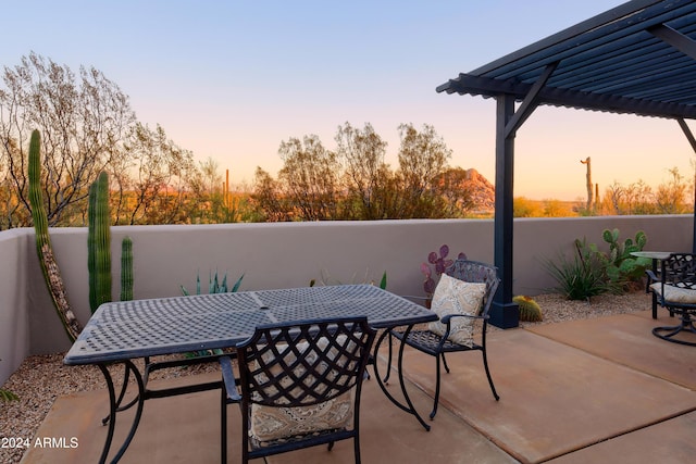 patio terrace at dusk featuring a pergola