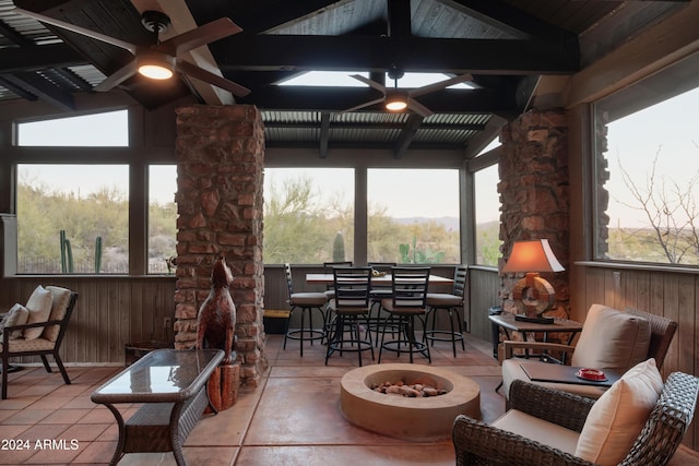 sunroom / solarium featuring vaulted ceiling with beams and ceiling fan