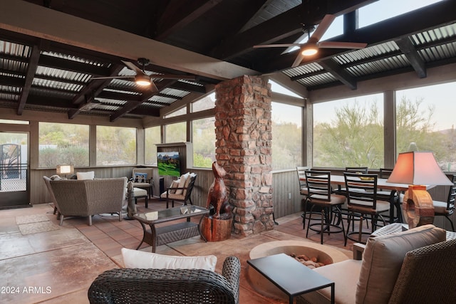 sunroom featuring lofted ceiling with beams, ceiling fan, and wooden ceiling