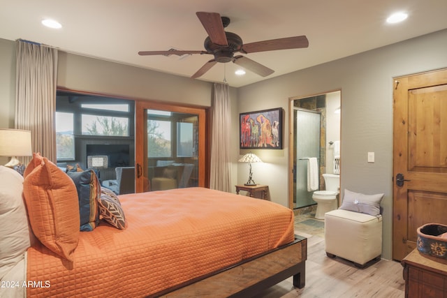 bedroom with ensuite bath, ceiling fan, and light hardwood / wood-style floors