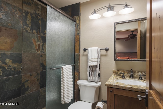 bathroom with ceiling fan, vanity, an enclosed shower, and toilet