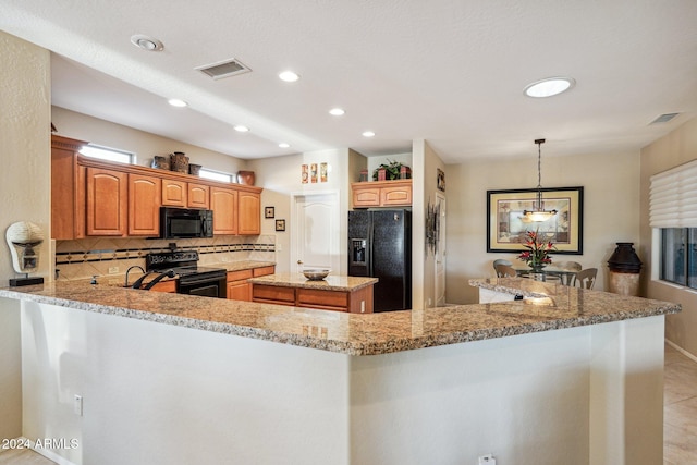 kitchen featuring pendant lighting, black appliances, tasteful backsplash, a kitchen island, and kitchen peninsula