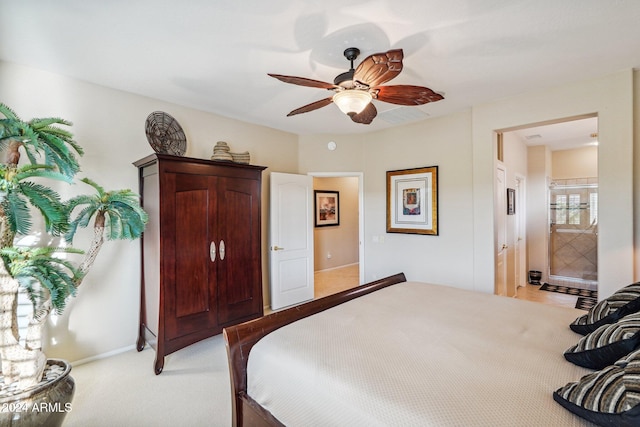 carpeted bedroom with ensuite bath and ceiling fan