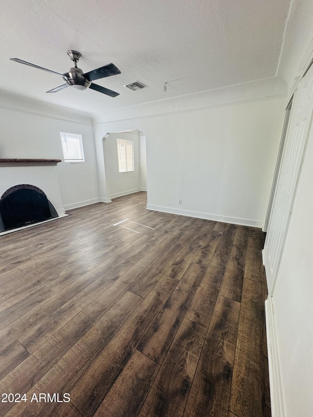 unfurnished living room with dark hardwood / wood-style floors, ceiling fan, and a textured ceiling