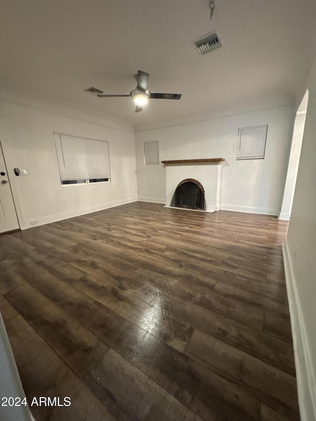 unfurnished living room with ceiling fan and dark wood-type flooring