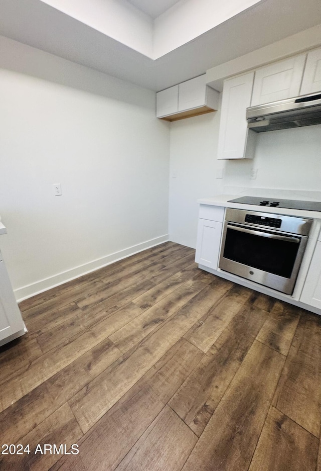 kitchen featuring stainless steel oven, dark wood-type flooring, exhaust hood, black electric stovetop, and white cabinetry