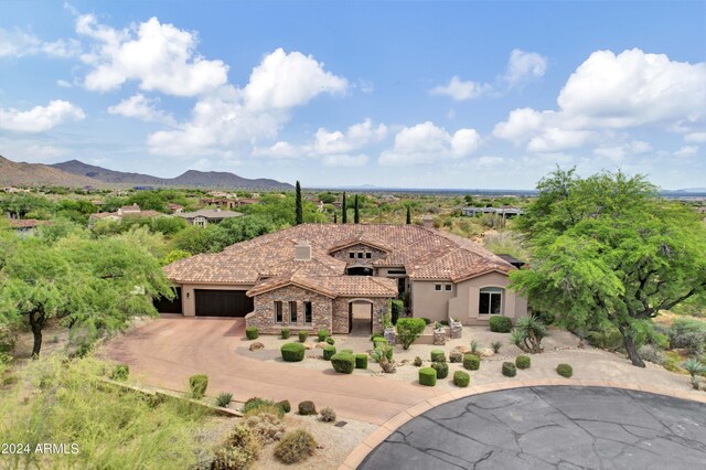 mediterranean / spanish-style house with a garage and a mountain view