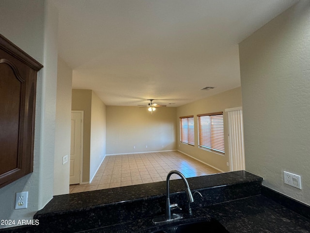 kitchen with light tile patterned floors, ceiling fan, and sink