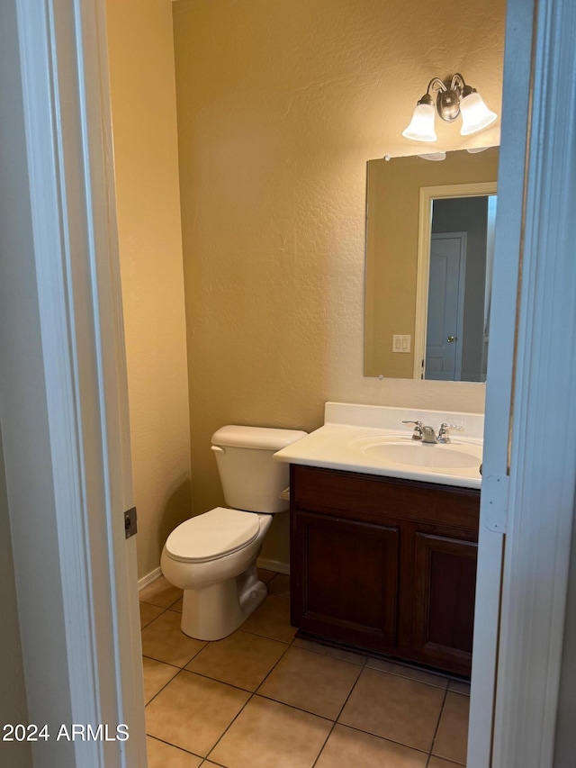 bathroom with tile patterned flooring, vanity, and toilet