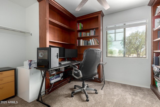 carpeted home office featuring a ceiling fan