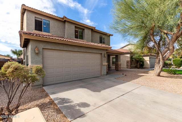 mediterranean / spanish home with stucco siding, concrete driveway, an attached garage, and a tiled roof