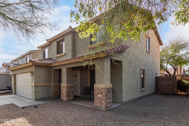 view of front of property featuring stucco siding, driveway, stone siding, a garage, and a tiled roof