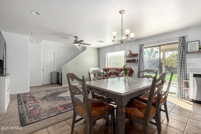 dining area featuring light tile patterned floors, visible vents, and ceiling fan with notable chandelier