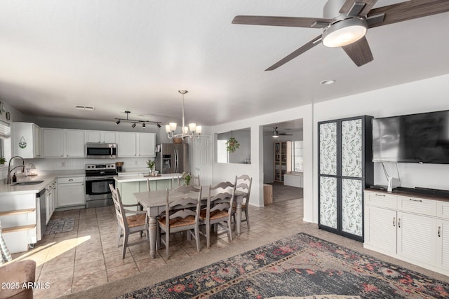 dining area featuring light tile patterned floors, visible vents, and ceiling fan with notable chandelier