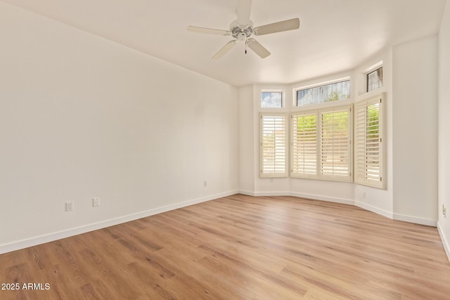 empty room with baseboards, a ceiling fan, and light wood-type flooring