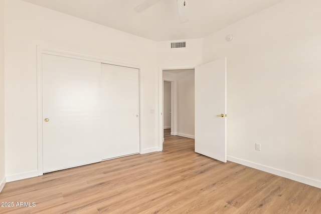 unfurnished bedroom featuring a closet, baseboards, visible vents, and light wood-type flooring