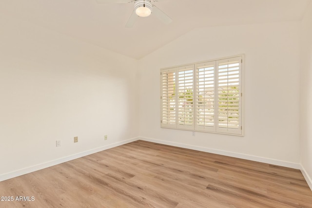 spare room featuring baseboards, ceiling fan, wood finished floors, and vaulted ceiling