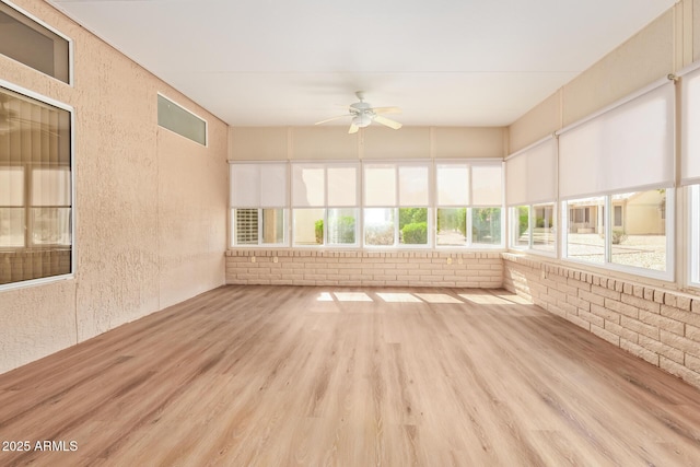 unfurnished sunroom with a healthy amount of sunlight and wood finished floors
