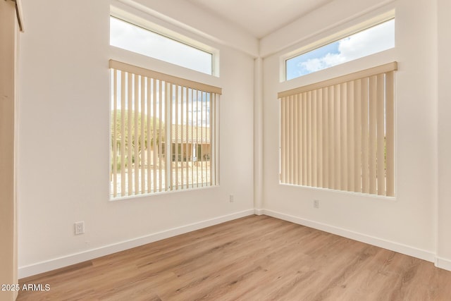 empty room featuring baseboards and wood finished floors