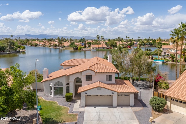 3520 N 110th Ave, Avondale, AZ 85392 - view of front of property with concrete driveway, a chimney, stucco siding, a tiled roof, and a water and mountain view