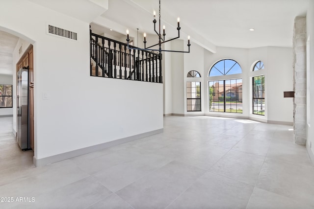 3520 N 110th Ave, Avondale, AZ 85392 - interior space with baseboards, a chandelier, a towering ceiling, arched walkways, and visible vents