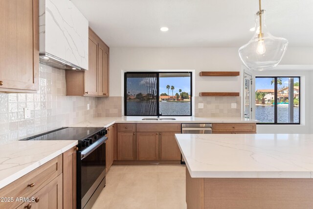 3520 N 110th Ave, Avondale, AZ 85392 - kitchen with light tile patterned floors, black electric range, premium range hood, and light stone counters