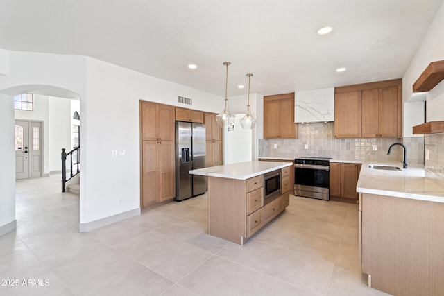 3520 N 110th Ave, Avondale, AZ 85392 - kitchen featuring stainless steel appliances, a center island, a sink, arched walkways, and visible vents
