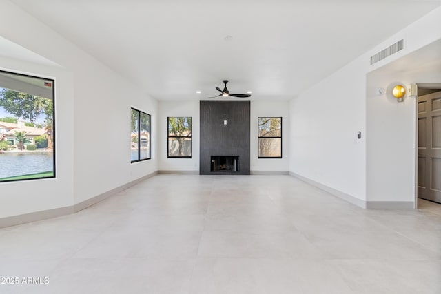 3520 N 110th Ave, Avondale, AZ 85392 - unfurnished living room with baseboards, visible vents, ceiling fan, and a fireplace