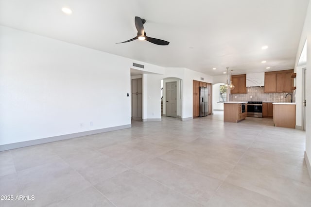 3520 N 110th Ave, Avondale, AZ 85392 - unfurnished living room featuring recessed lighting, baseboards, arched walkways, visible vents, and a ceiling fan