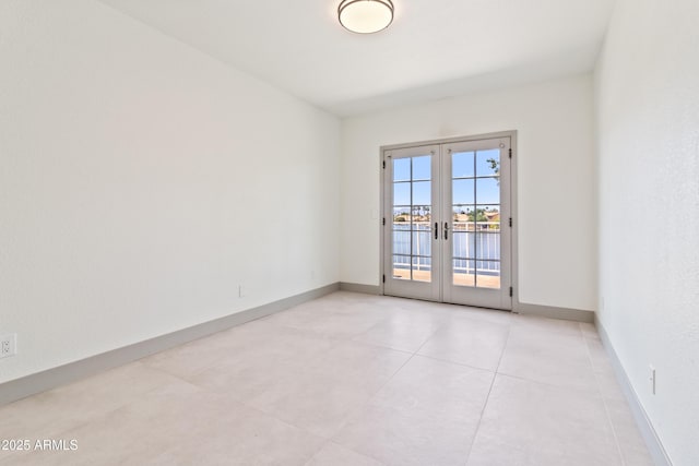 3520 N 110th Ave, Avondale, AZ 85392 - unfurnished room with baseboards, a water view, french doors, and light tile patterned floors