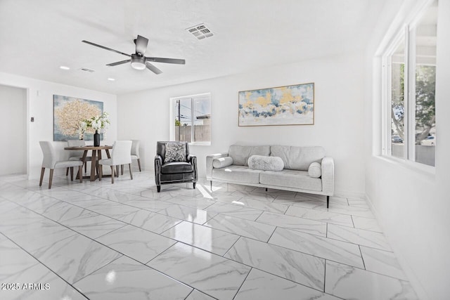 unfurnished living room featuring visible vents, marble finish floor, and ceiling fan