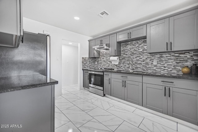 kitchen with gray cabinetry, under cabinet range hood, marble finish floor, stainless steel appliances, and a sink