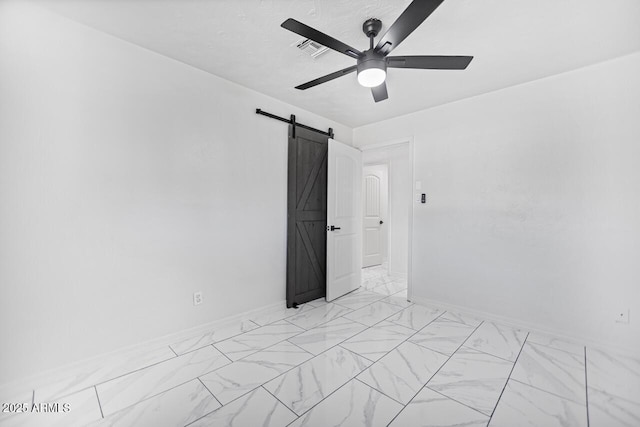 unfurnished room featuring visible vents, marble finish floor, baseboards, and a barn door