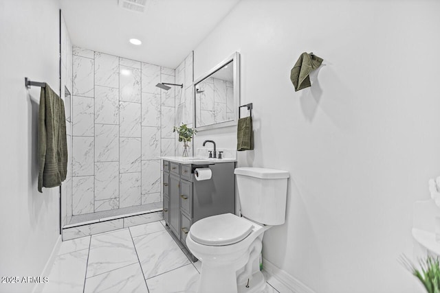 full bathroom with toilet, marble finish floor, a tile shower, baseboards, and vanity