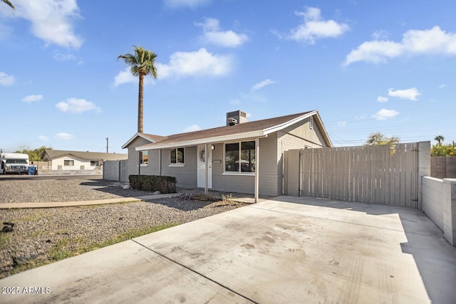 view of front facade featuring fence, central AC unit, and a gate