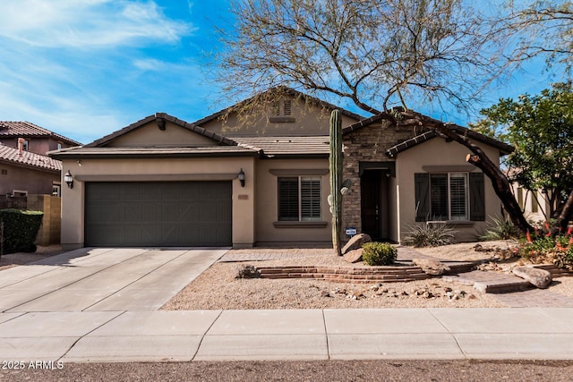 view of front of home featuring a tile roof, stucco siding, concrete driveway, a garage, and stone siding