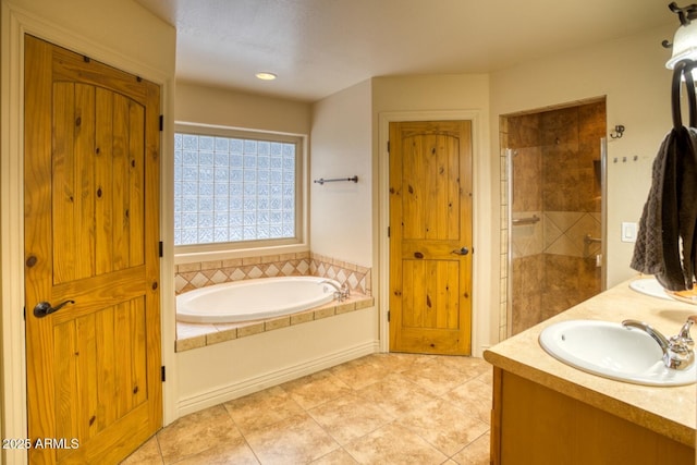 bathroom with tile patterned floors, vanity, and separate shower and tub