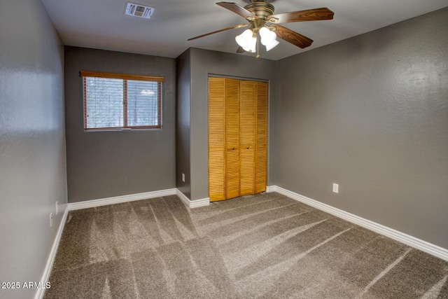 unfurnished bedroom with carpet flooring, ceiling fan, and a closet