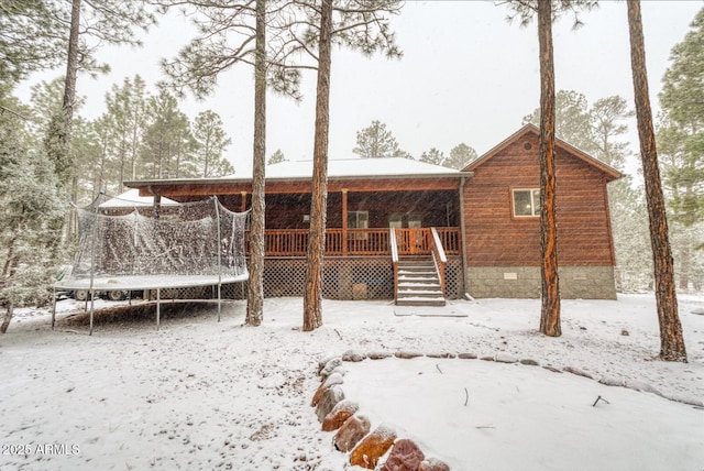 snow covered house with a trampoline