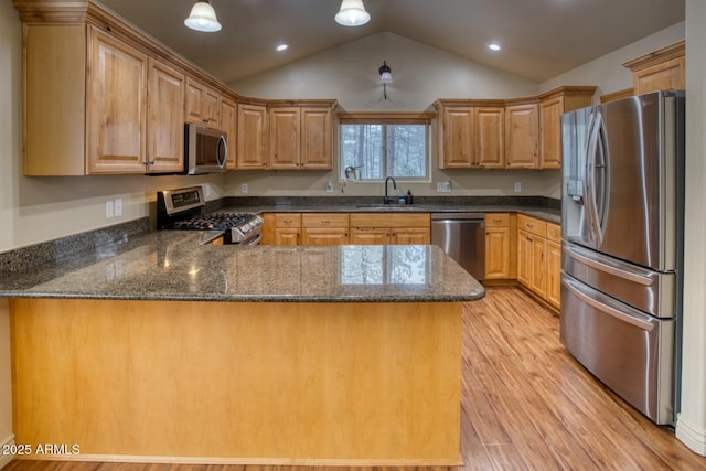 kitchen with lofted ceiling, sink, light wood-type flooring, kitchen peninsula, and stainless steel appliances