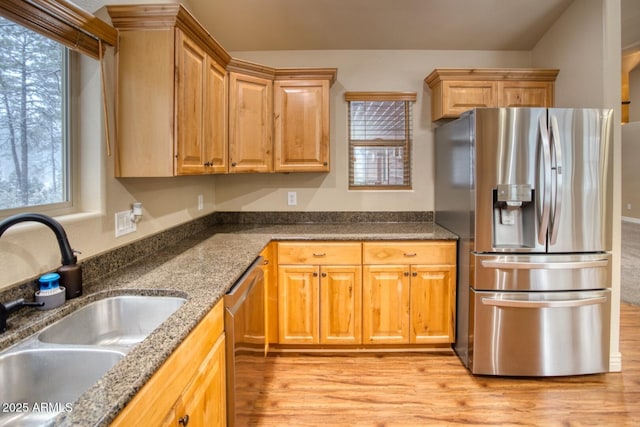 kitchen with a healthy amount of sunlight, dark stone countertops, sink, and appliances with stainless steel finishes