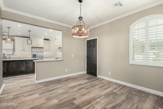 1051 E Julie Ave, San Tan Valley, AZ 85140 - kitchen featuring crown molding, tasteful backsplash, visible vents, stainless steel fridge, and baseboards